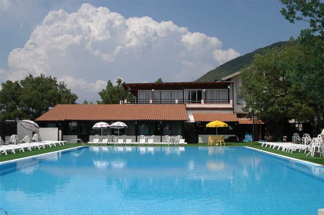 Piscina con sdraio e ombrelloni.