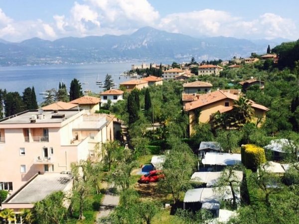 Vista di un villaggio sul lago con montagne in lontananza.