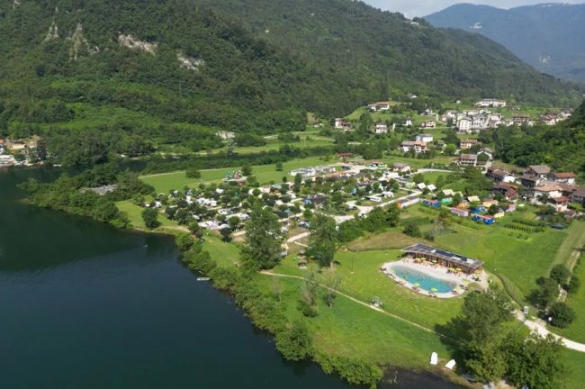 Vista aerea di un campeggio vicino a un lago e montagne.