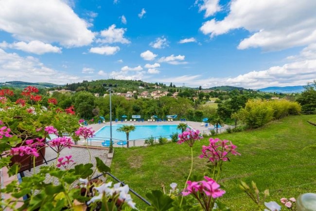 Piscina panoramica con vista collinare.