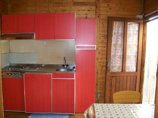Cucina in legno con armadietti rossi.