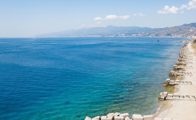 Costa con mare azzurro e scogliere.