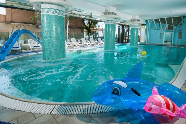 Piscina coperta con scivoli e giochi gonfiabili.