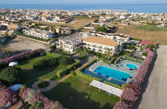 Vista aerea di un complesso con piscina e giardini.