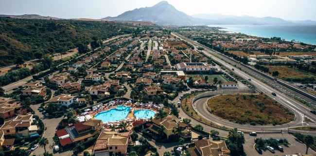 Vista aerea di un villaggio turistico con piscina.