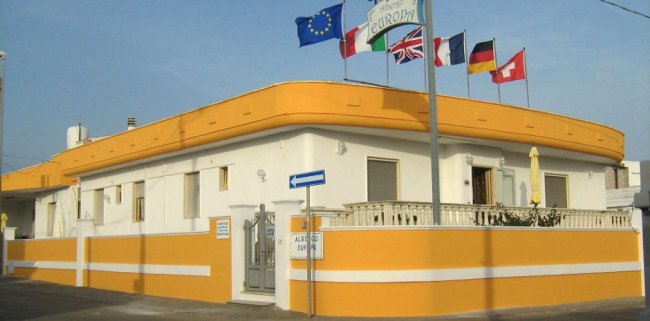 Edificio giallo-bianco con bandiere.