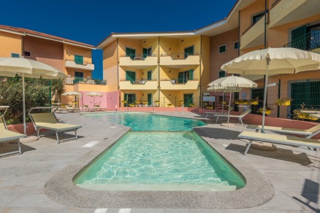 Piscina circondata da ombrelloni e lettini.