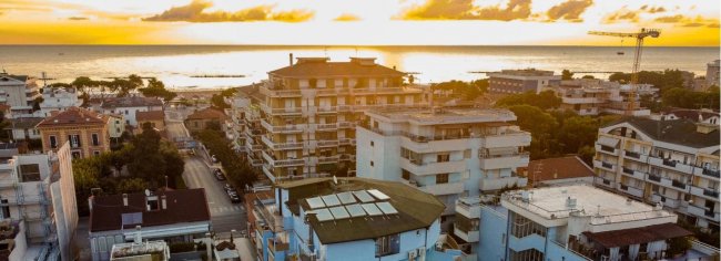 Tramonto su edifici vicino al mare.