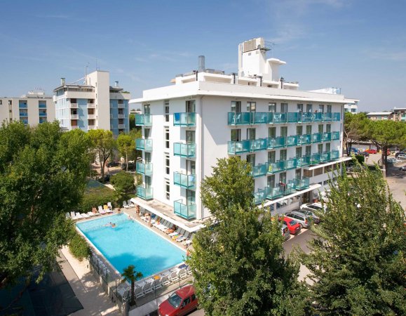 Edificio bianco con balconi e piscina.