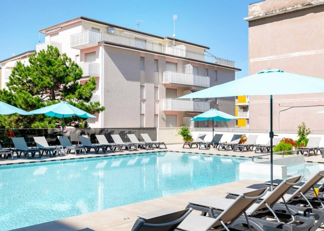 Piscina con ombrelloni e lettini.