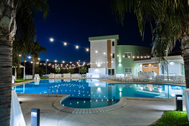 Piscina illuminata di notte con decorazioni luminose.