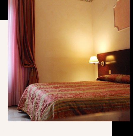 Camera da letto con lenzuola colorate e luce calda.