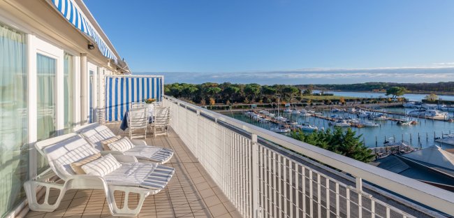 Terrazza con lettini e vista sul porto.
