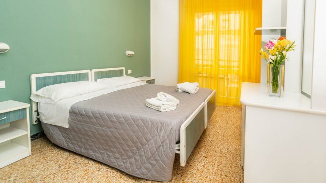 Camera con letto matrimoniale e tende gialle.