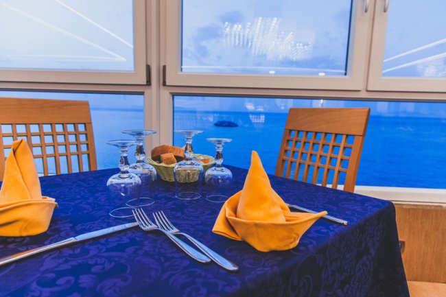 Tavolo elegante con tovaglia blu e tovaglioli arancioni.