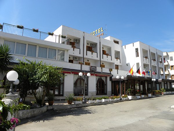 Facciata di un hotel bianco con bandiere.