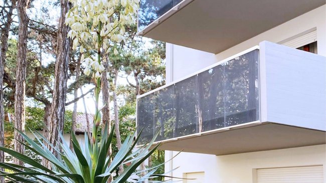 Balconi esterni con alberi e siepi.