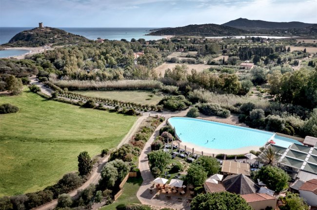 Vista aerea di una piscina, campagna e mare.