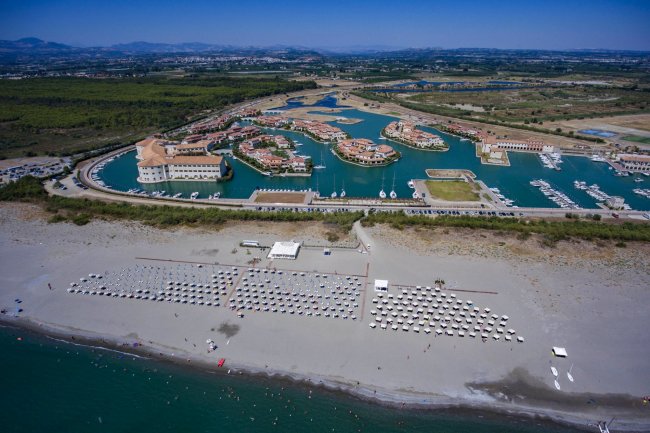 Vista aerea di un resort con spiaggia e marina.