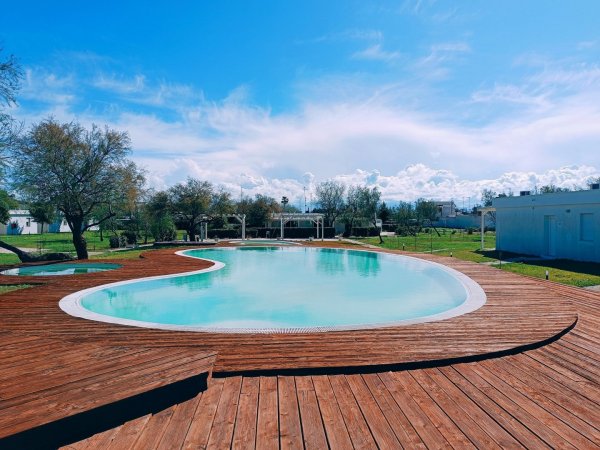 Piscina all'aperto con piattaforma di legno.