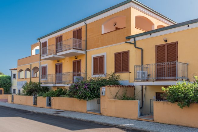 Edificio giallo a due piani con balconi.