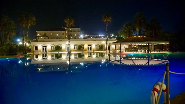 Edificio illuminato con piscina di notte.