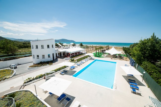 Piscina all'aperto con vista mare e lettini.