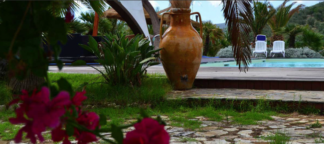 Grande anfora, fiori e piscina sullo sfondo.