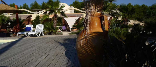 Grande giara, sdraio e palme su una terrazza.