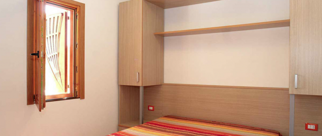 Camera da letto con finestra aperta.