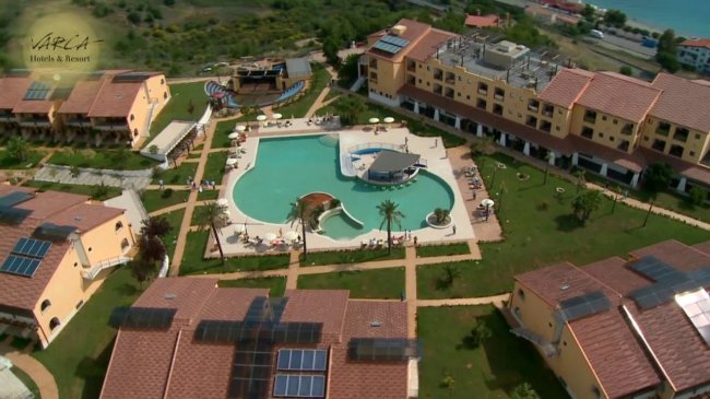 Vista aerea di un resort con piscina centrale.
