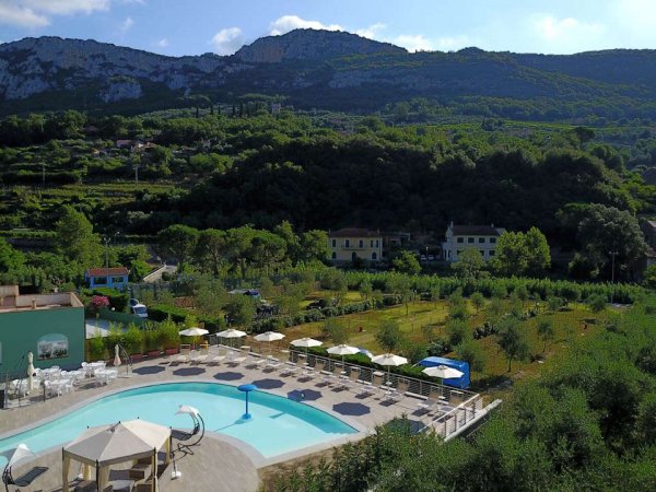 Piscina immersa nel verde con vista montagna.