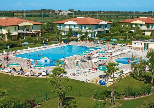 Piscina all'aperto con lettini e ombrelloni.