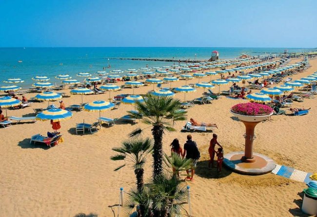 Spiaggia con ombrelloni e sedie a sdraio.