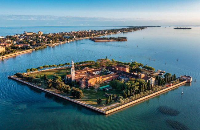 Isola verde con edifici e campanile.