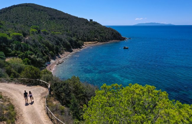 Sentiero costiero con vista sul mare e una coppia che cammina.