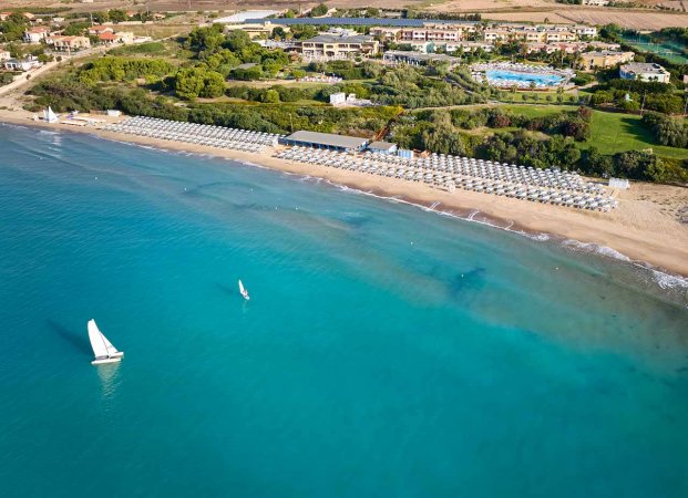 Spiaggia con ombrelloni e mare azzurro.