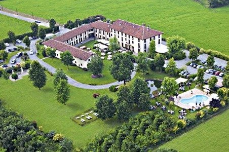 Vista aerea di una tenuta con piscina circondata da alberi.