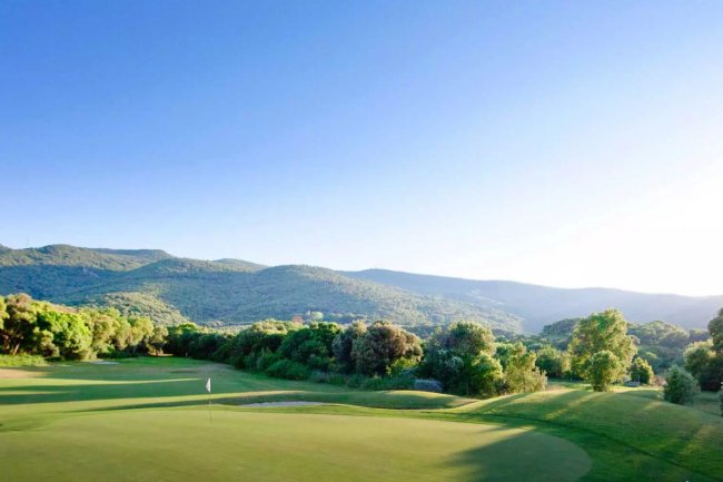 Campo da golf con colline verdi.