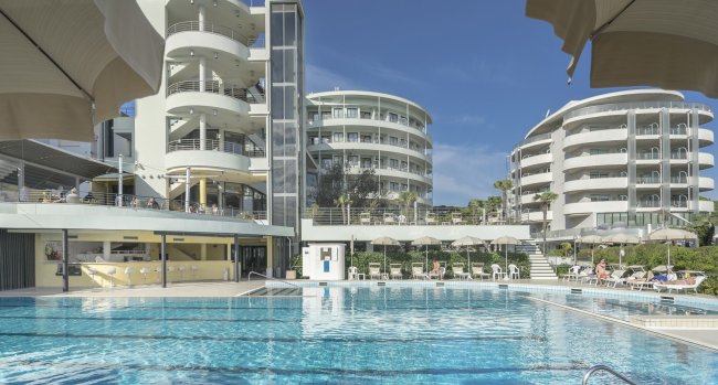 Piscina con edifici moderni sullo sfondo.