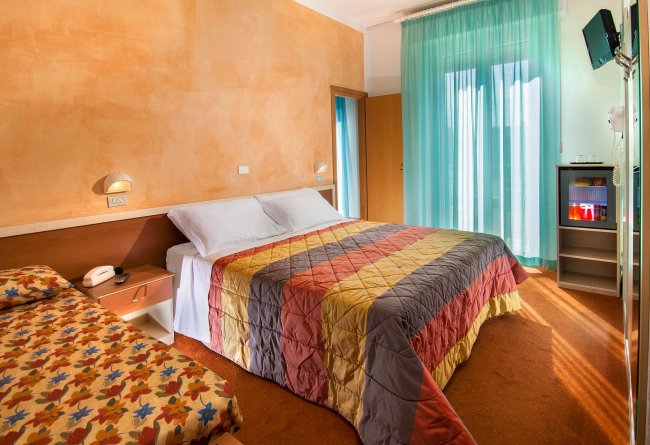 Camera con letto matrimoniale e tenda azzurra.