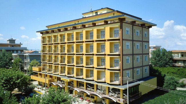 Edificio giallo a più piani con balconi.