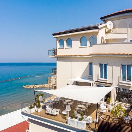 Terrazza sul mare con tavoli e sedie.