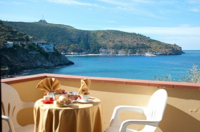 Tavolo con colazione su terrazza vista mare.