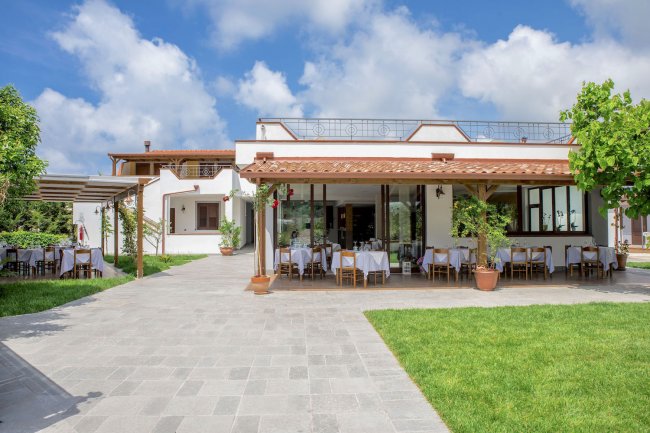 Edificio con tavoli apparecchiati all'esterno.