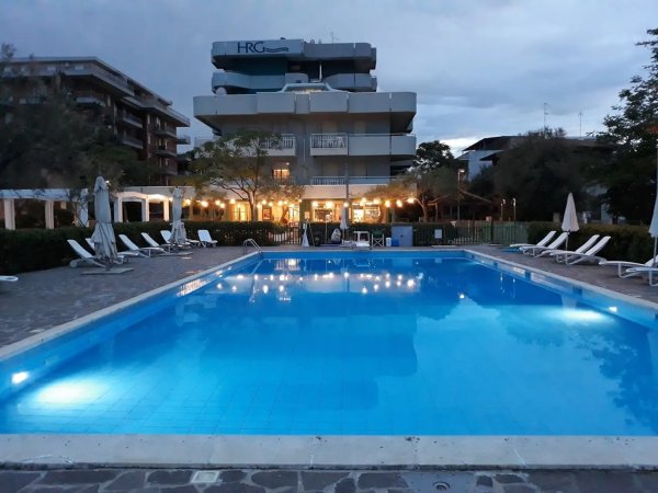 Piscina illuminata davanti a un edificio.