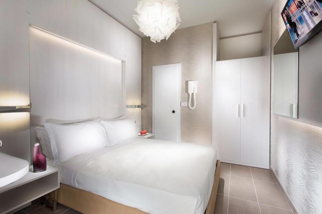 Una camera moderna con letto matrimoniale e armadio bianco.