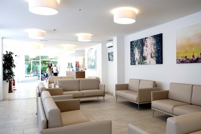 Sala d'attesa con divani beige.