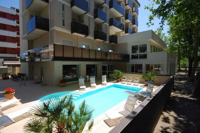 Edificio moderno con piscina e balconi.