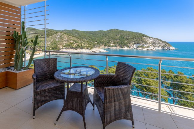Balcone con tavolino e sedie vista mare.